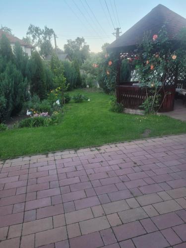 a yard with a garden with flowers and a house at Pensiunea Diana in Arefu