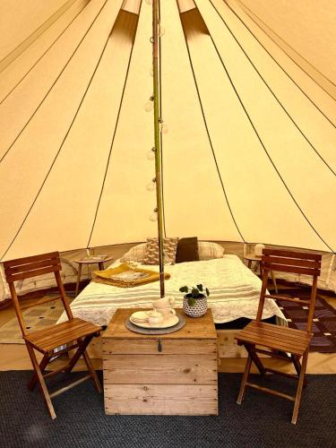 a tent with a bed and two chairs and a table at Rondane Friluftssenter Rondetunet in Brenn