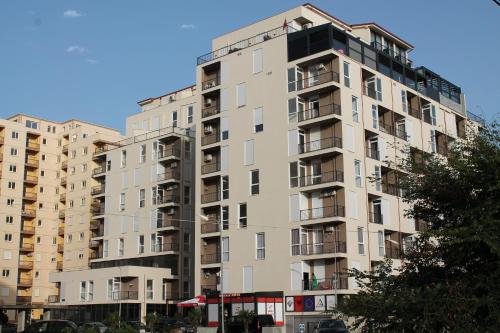 a tall apartment building with balconies on a street at Holiday Gateway in Shëngjin