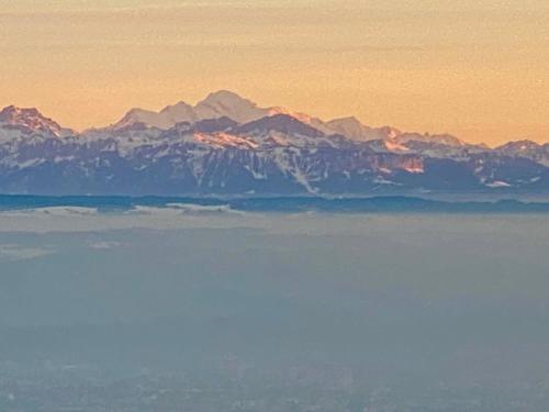 a view of a mountain range from above the water at Chalet avec vue panoramique alpes et lac in Mauborget