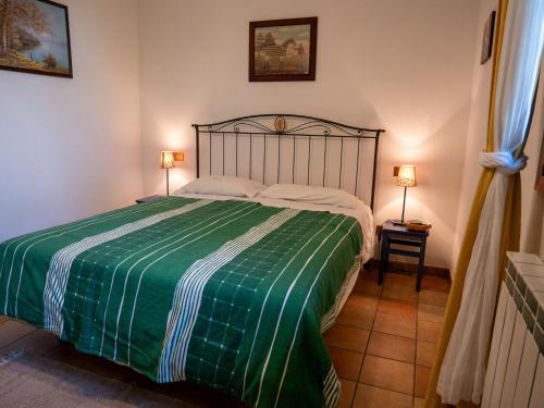 a bedroom with a bed with a green and white blanket at Agri Borgata Vallone - Apartments - by HOST4U in Lecchiore