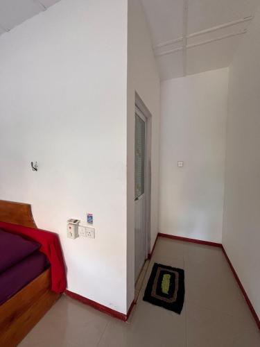 a white room with a bed and a window at Crystal Bay in Arugam Bay