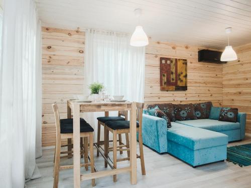 a living room with a blue couch and a table at Hapsal Forest Cabin in Haapsalu