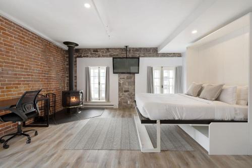 a bedroom with a bed and a brick wall at Hotel Port-Royal in Quebec City