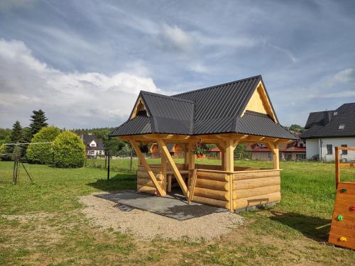 a wooden gazebo with a black roof at "Podhalański Gościniec" -250 m Gorący Potok ,Termy Szaflary in Szaflary