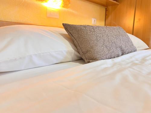 un letto bianco con un cuscino sopra di Bed & Breakfast Rab a Rab