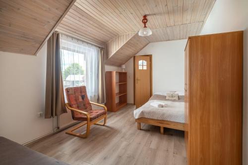 a bedroom with a bed and a chair and a window at WDZYDZANIN in Wdzydze Tucholskie