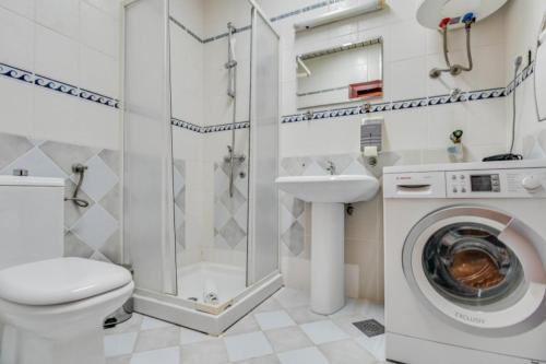 a bathroom with a toilet sink and a washing machine at Apartmani Trg in Zlatibor