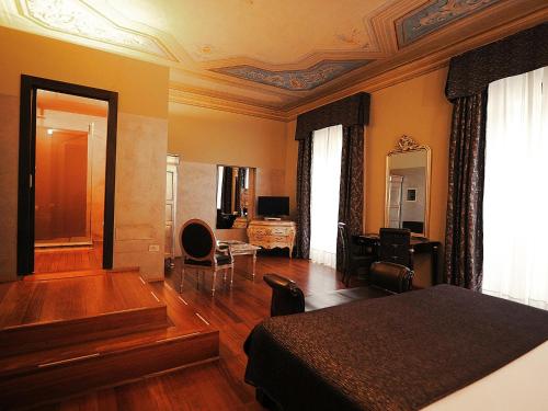sypialnia z łóżkiem i salonem w obiekcie Borghese Palace Art Hotel we Florencji
