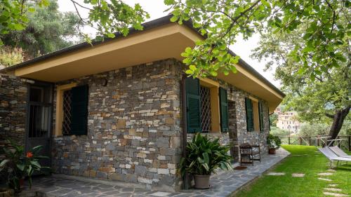 a stone house with green shutters and a patio at Agri Borgata Vallone - Apartments - by HOST4U in Lecchiore
