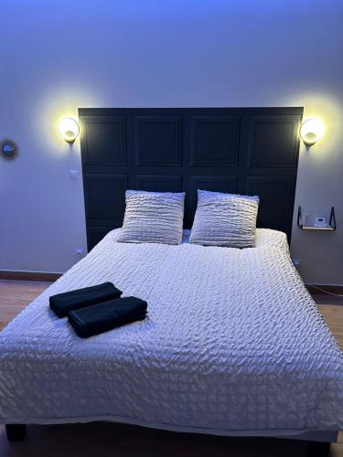 - un lit avec 2 serviettes noires dans l'établissement L evazion appartement Grenoble, à Grenoble