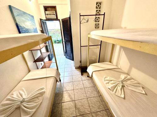 a kitchen with two stools in a room with a hallway at Hostel e Pousada Barra da Tijuca in Rio de Janeiro