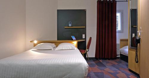 a hotel room with a bed and a desk and a bed sidx sidx at In Hotel Nancy Frouard in Frouard