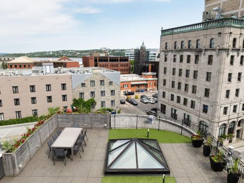a balcony with a table and benches and buildings at Hotel Port-Royal in Quebec City