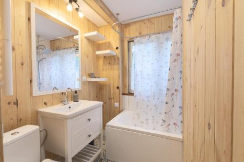 a bathroom with a toilet and a sink and a tub at Chata 'Leśne Kurki' in Kurki