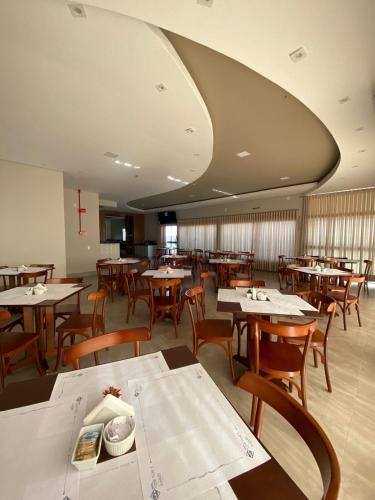 a dining room with wooden tables and chairs at Visionsul Hotel in Chapadão do Sul