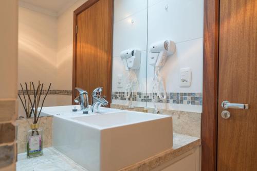 a bathroom with a white sink and a mirror at Apartamentos Monte Felice Stay in Gramado