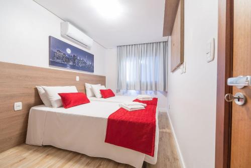 a bedroom with a bed with a red blanket on it at Apartamentos Monte Felice Stay in Gramado