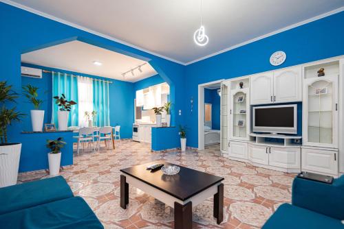 Sala de estar azul con sofá y mesa en Vila al3, en Durrës