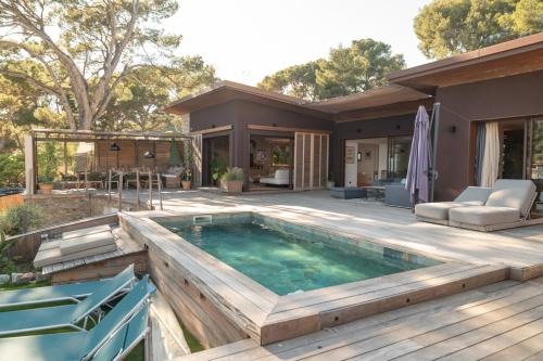 une piscine avec une terrasse et une maison dans l'établissement Villa luxueuse en bord de mer, à La Seyne-sur-Mer