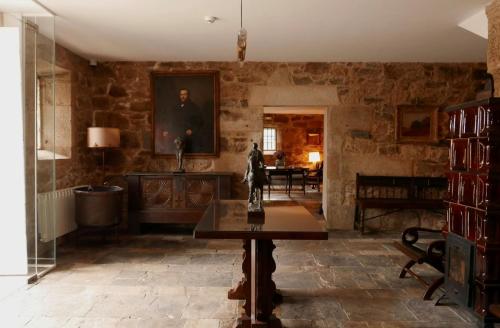 a living room with stone walls and a table at Hotel Pazo de Bieite in Boimorto