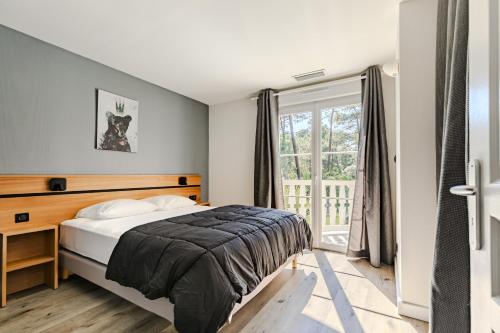 une chambre avec un lit et une fenêtre dans l'établissement Villa rénovée,piscine chauffée, dans les pins à 4min de l'océan-AG29, à Lacanau