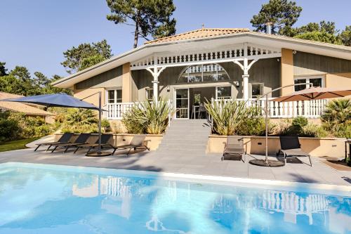 une maison avec une piscine devant une maison dans l'établissement Villa rénovée,piscine chauffée, dans les pins à 4min de l'océan-AG29, à Lacanau