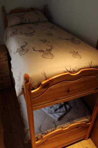 a bed with a wooden frame with deer drawings on it at Appartamento Val Da Rin - Vista sulle Tre Cime in Auronzo di Cadore
