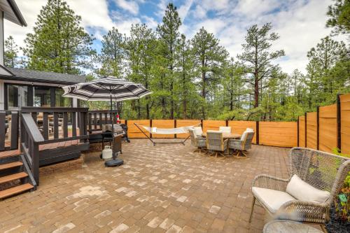 a patio with a table and chairs and an umbrella at Wraparound Deck and Poker Room Cabin in Munds Park in Munds Park