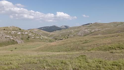 a grassy hillside with mountains in the background at Amelia Sweet Home - Farindola in Farindola