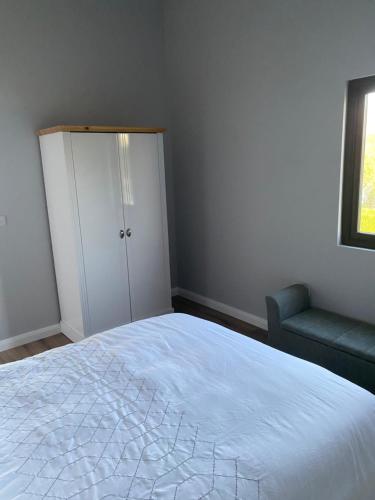 a bedroom with a bed and a chair and a window at Killyfole lakeside lodges in Corranny
