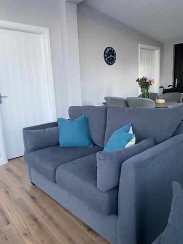 a blue couch with blue pillows in a living room at Killyfole lakeside lodges in Corranny