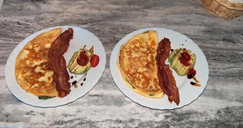 twee ontbijtgerechten met spek en eieren bij The Parrsboro Mansion Inn in Parrsboro