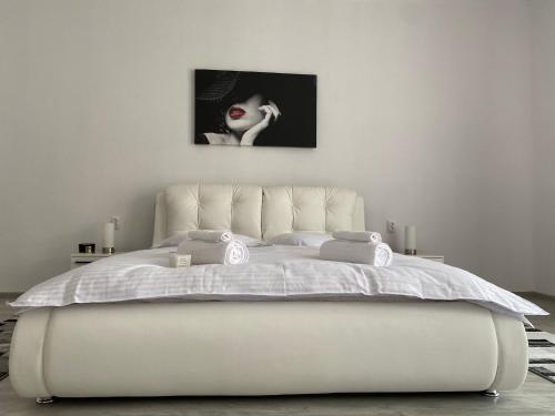 a white bed in a bedroom with a woman with red lipstick at Casa Ama in Steierdorf