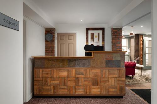 a lobby with a reception desk and a red chair at Trafford Hall Hotel Manchester, Trademark Collection by Wyndham in Manchester