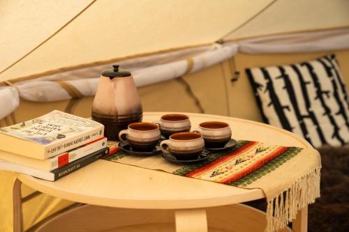 a table with books and a tea set on it at Countryside tent near Tõrva in Jõgeveste