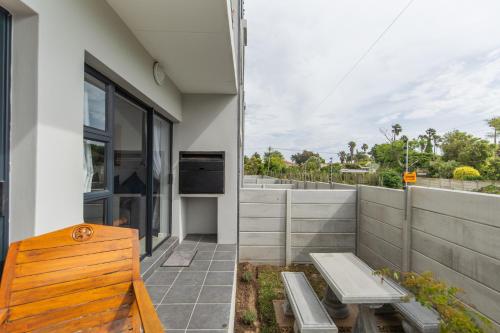 a building with a bench and a balcony with a view at Jetsetter's Retreat Apartment in Hallack Rock