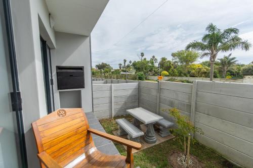 a wooden bench sitting on the balcony of a house at Jetsetter's Retreat Apartment in Hallack Rock