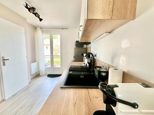 a kitchen with a sink and a stove at Le Feuillardier, calme et lumineux in Limoges