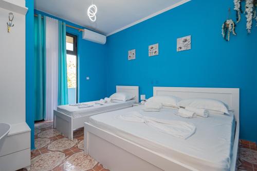 1 dormitorio azul con 2 camas en una habitación en Vila al3, en Durrës