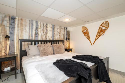a bedroom with a large bed with white sheets at Lake House Chalet Laurentians in Nominingue