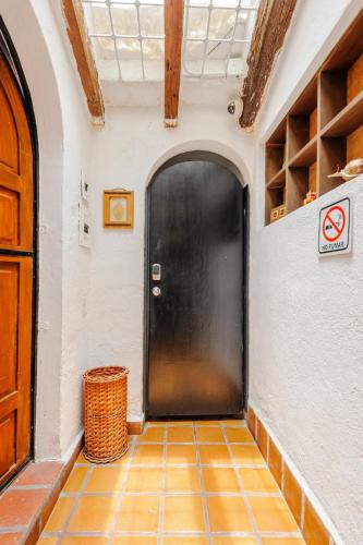 a black door in a room with a tiled floor at Casa Aimée in Mexico City
