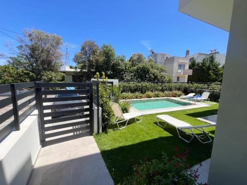 a backyard with a swimming pool and a fence at Green Villa in Ialyssos