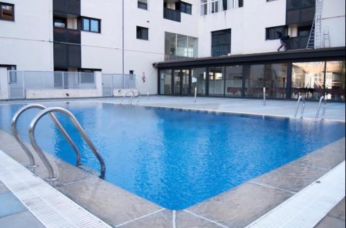 a large swimming pool in front of a building at VIP Suites in Murcia