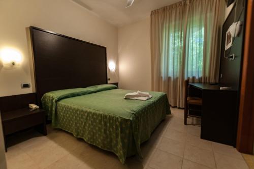 a hotel room with a bed and a desk at Hotel Orsini in Caramanico Terme