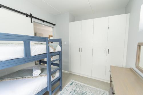 a bedroom with two bunk beds and a desk at Jetsetter's Retreat Apartment in Hallack Rock