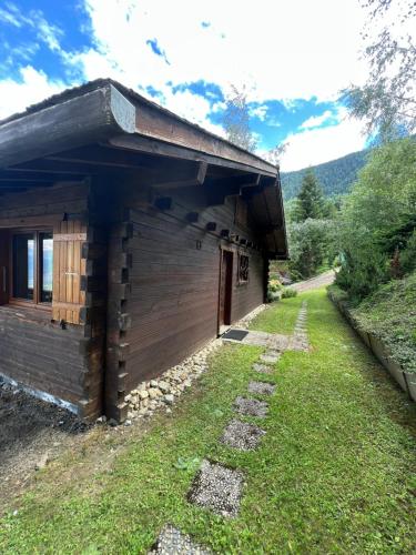 a log cabin with a grass yard in front of it at Chalet cocooning en pleine nature in Saxon