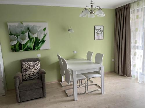 Un comedor con una mesa y sillas blancas. en Studio Vila Roma, en Nesebar
