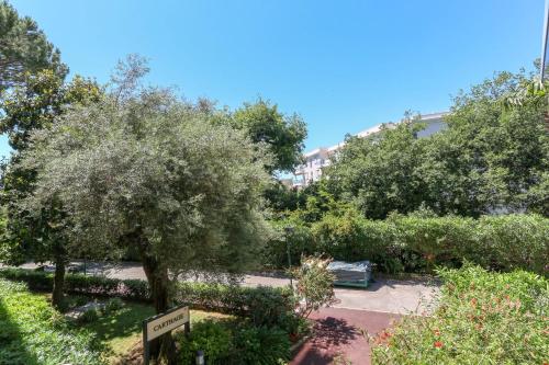un parc avec des arbres et un bâtiment en arrière-plan dans l'établissement Studio in Antibes with AC Terrace & Pool - BENAKEY, à Antibes