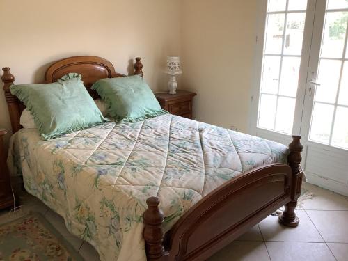 - une chambre avec un lit et des oreillers verts dans l'établissement Villa au calme, à Vidauban